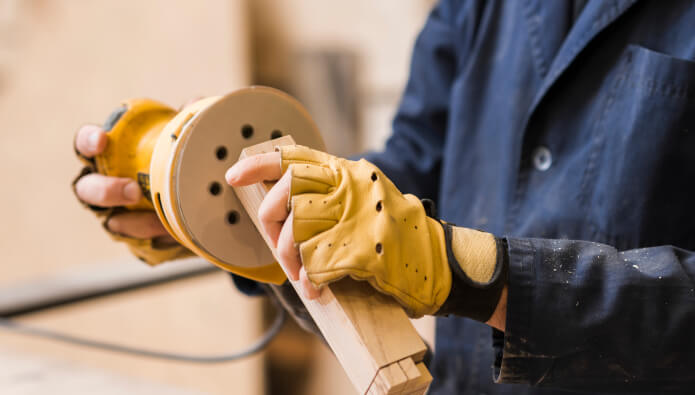 close-up-male-carpenter-sanding-wooden-block-with-sander 2